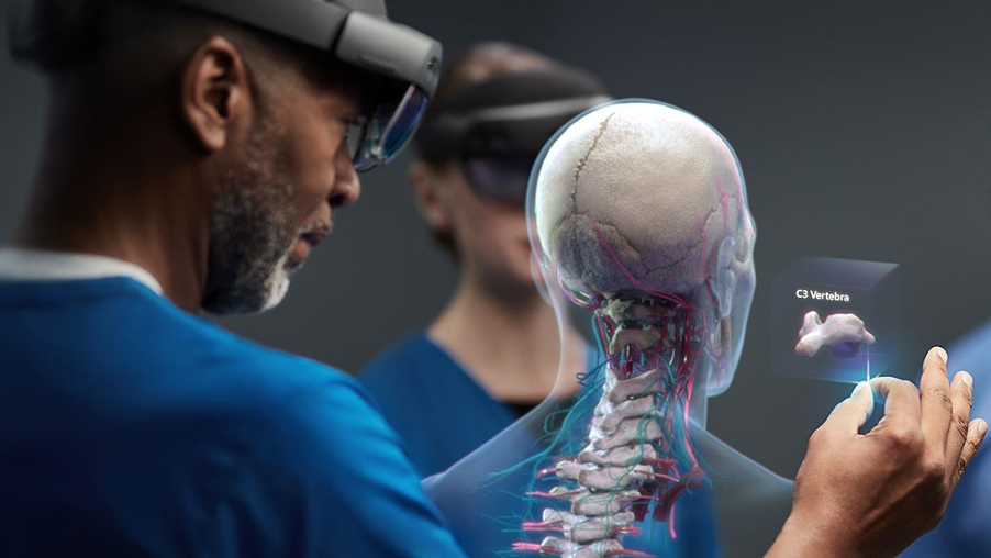 Healthcare worker wearing HoloLens 2 headset looks at hologram of the C3 vertebra