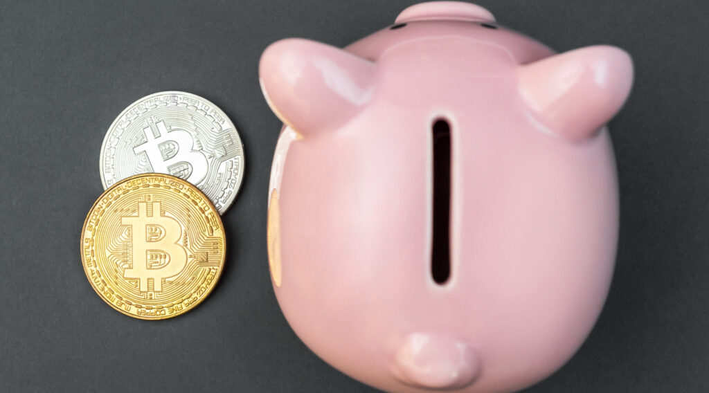 piggy-bank-with-coins-of-bitcoin-on-black-top-view